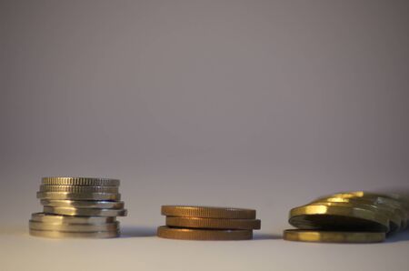 Three columns of coins. The last one is fallenの写真素材