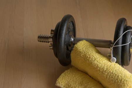 Dumbbell with towel and with white headphonesの写真素材