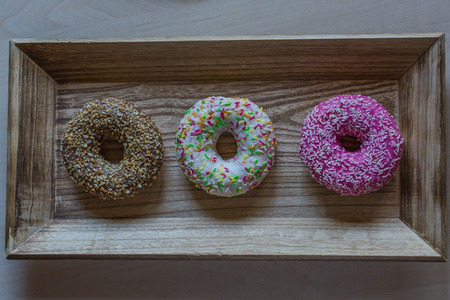 Sweet donuts on wooden plateの写真素材
