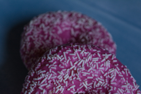 Sweet pink donuts on blue wood plateの写真素材