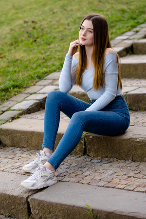 Young girl portrait sitting on stairs in parkの写真素材
