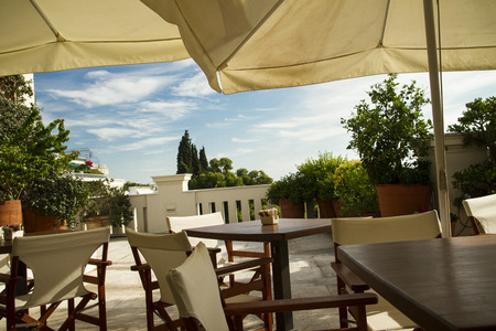 Garden Terace of a cafe restaurant. Tables, chairs and plants on sunny day.