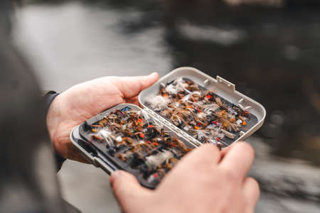 Man holding fly fishing lures boxの写真素材