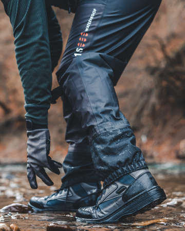 Fishing boots for wading in the river, fishing gloves water proof, shoes close-up in riverの写真素材
