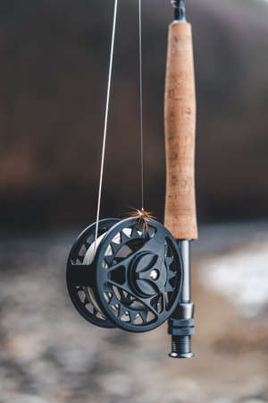 Fly fishing reel with rod in natural blury backgroundの写真素材