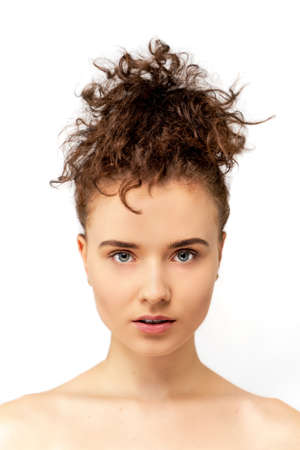 Beauty young woman studio portrait with perfect eyes, lips, clean fresh skin and curly hair. White isolated background. Vertical shot for beauty, welness, skin care and fashion model.の写真素材