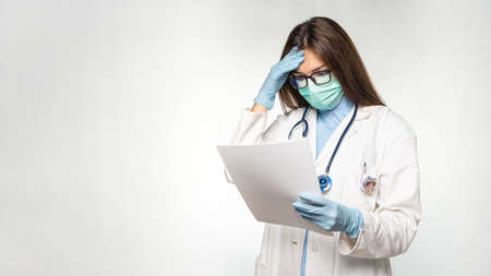 Young female caucasian doctor reading documents.の写真素材