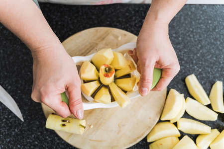 Young housewife cutting apple with tool for apple pie.の写真素材