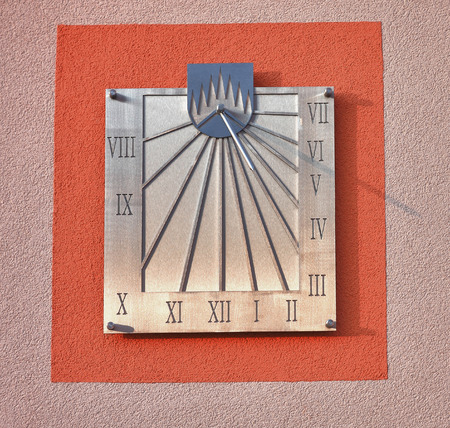 Sundial on facade of  house in sunny day