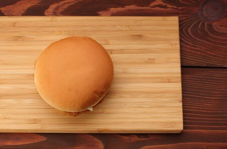 Chicken burger on bamboo board on wooden table.の写真素材