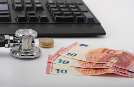 Stethoscope,money, keyboard on white, medical concept.の写真素材