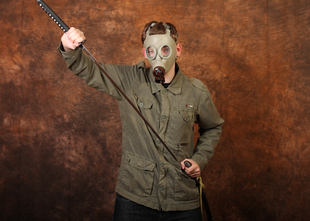 Man with gas mask and  katana sword on brown batik background