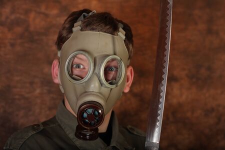 Man with gas mask and  katana sword on brown batik background