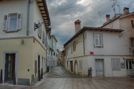 Old town street with store in Koper in Slovenia in cloudy weatherの写真素材