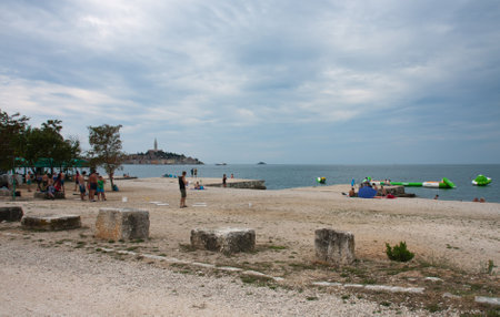 ROVINJ,CROATIA AUGUST 21,2015:Group of people, tourists from all over Europe enjoying rest on August 21,2015 on town beach in Rovinj in Croatia. Rovinj is a popular tourist destination in Croatia.のeditorial素材