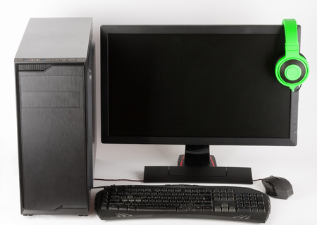 Midi tower computer case with led monitor, keyboard, mouse and headphones on white background, new, modern gaming PCの写真素材