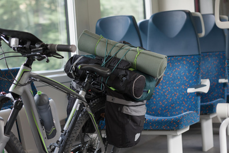 Mountain bike with saddlebags  is transported in public transportation, inside in the train.の写真素材