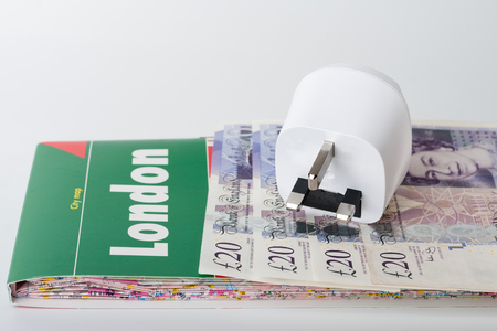 White travel power adapter, European to UK and map of London and British pounds.の写真素材