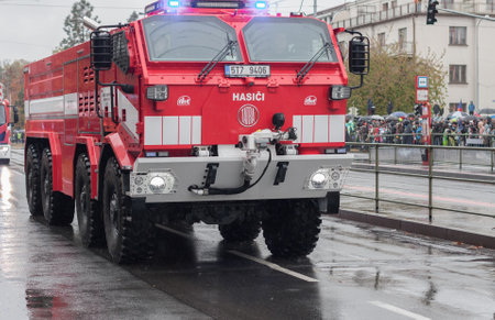 European street, Prague-October 28, 2018: Fire brigade workers are riding fire truck on military...