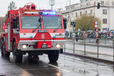 European street, Prague-October 28, 2018: Fire brigade workers are riding fire truck crane on...