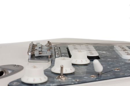 Close up of bridge  of white electric guitar, studio shoot.  2 x Single Coil and 1 x Humbucking. Black Pearl pickguardの写真素材