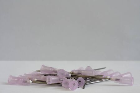 Close up of several of medical injection needles on white background