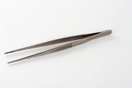 Medical surgical dressing tweezer on white background, tool used in wound treatment in ICU.