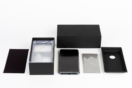 Unboxing of touchscreen smartphone, paper box and clean cloth. Studio shoot on white background.の写真素材