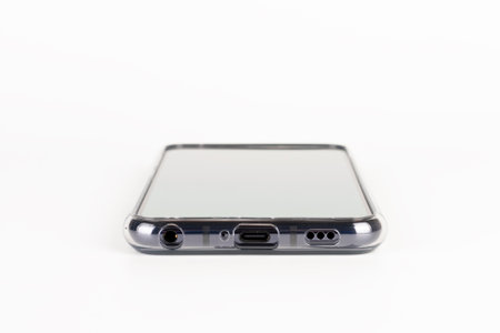 Close up of ports of touchscreen smartphone in silicone cover. USB-C, headphone jack, 1W speaker...