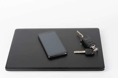 Modern office black laptop and touchscreen smarthphone and car keys, business concept.の写真素材