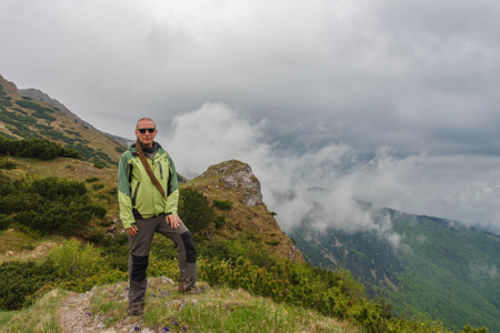 Hiker with dreadlocks on mountain pass Bublen, Mala Fatra, Slovakia. in spring cloudy day