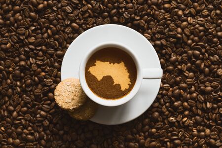 Still life photography of hot coffee beverage with map of Guineaの写真素材