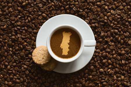 Still life photography of hot coffee beverage with map of Portugalの写真素材