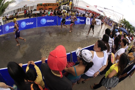 CAMARINES SUR- Aug. 14: Participants of Cobra Energy Drink Ironman 70.3 Philippines running from the swim to bike transition in Camarines Sur, Philippines on Sunday August 14, 2011.のeditorial素材