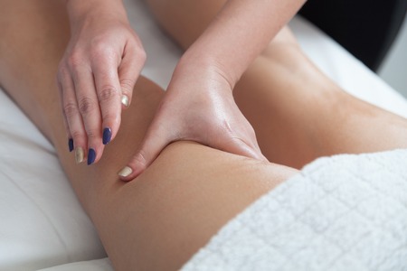 Masseur makes anti-cellulite massage young woman isolated on white backgroundの写真素材