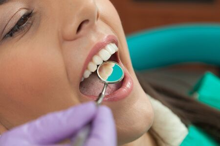 Close-up of female with open mouth during oral checkup at the dentist.Dentist
