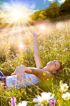beautiful young girl lying in a sunset marguerite meadowの写真素材