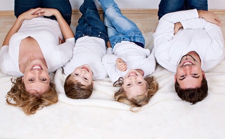 sweet young family having fun on the floor in their homeの写真素材