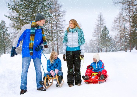 young funny family is sledging in winter-landscapeの写真素材