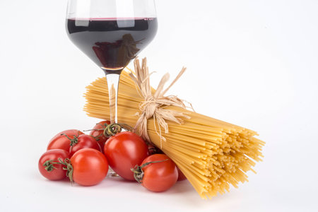 Italian pasta spaghetti with tomatoes and goblet of wineの写真素材