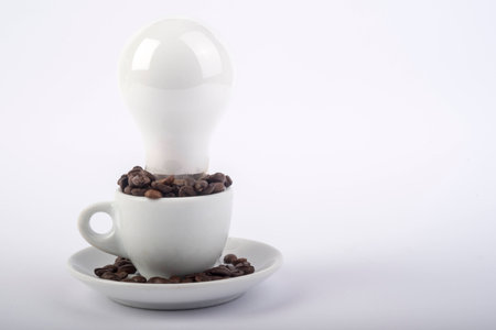 Coffee beans in the cup with light bulbの写真素材