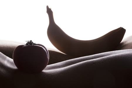 Bodyscape with tomato and banana silhouettes on woman backの写真素材