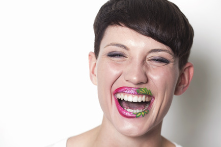 Beautiful woman with strawberry lips laughingの写真素材