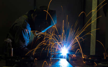 Worker welding construction by MIG welding, Worker welding the steel part by manual, welding...