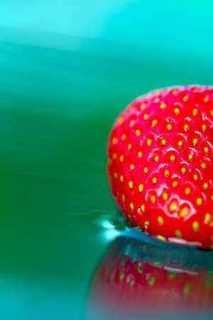 A fresh strawberry dipped in crystal clear spring waterの写真素材