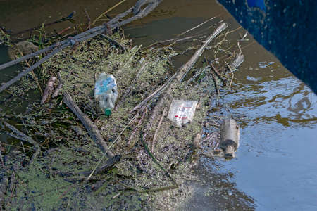 Floating old garbage in water, plastic bottles