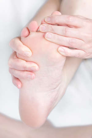 Bare feet feel pain with foot massageの写真素材