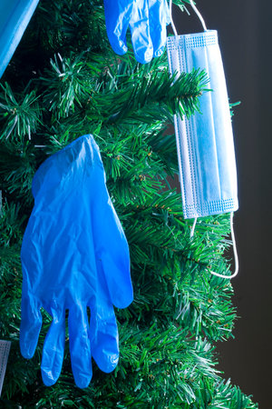 Covid Christmas holidays. Masks and gloves hung on the Christmas tree