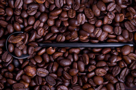 Coffee beans on a black spoonの写真素材