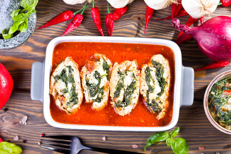 chicken rolls with spinach and mozzarella in tomato sauceの写真素材